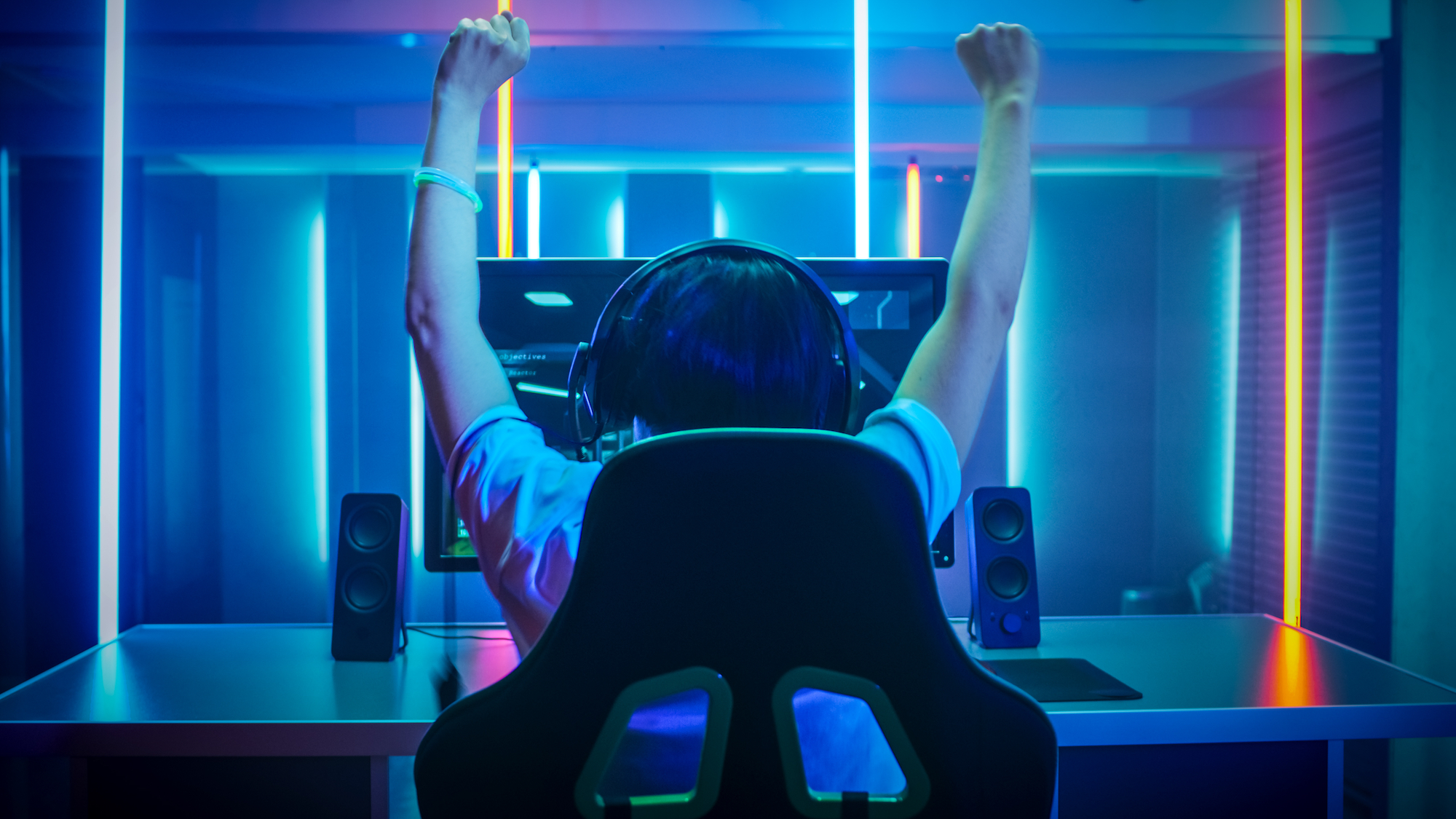 A person is shown celebrating a win while playing a video game.